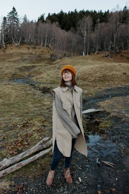 Turuncu şapkalı genç kadın. Sonbahar nehri rahatlaması.