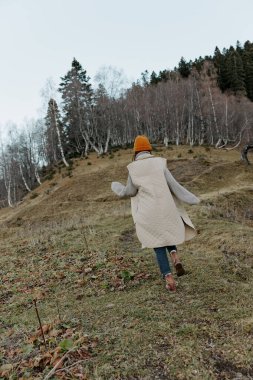 Kadın sonbahar hava durumu dağları manzarası için dışarı çıkıyor.