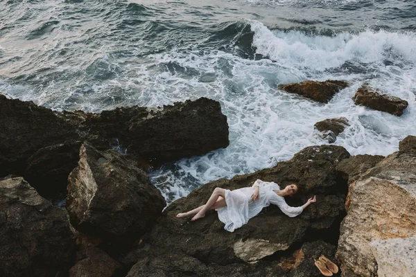 Woman in a white dress lying on a stone in a white dress vacation concept — Stock Photo, Image