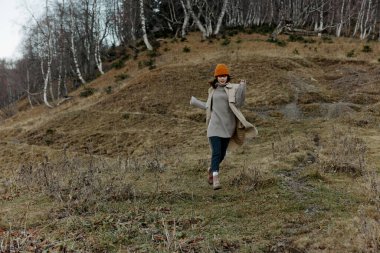 Sonbahar kıyafetleri içindeki turist doğa ağaçları yaşam tarzıyla seyahat eder.