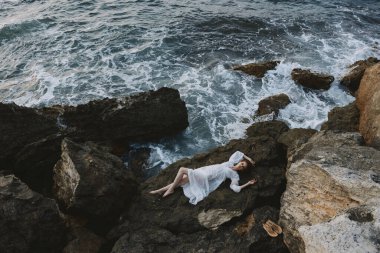 Deniz kıyısında beyaz gelinlik içindeki güzel gelin yukarıdan ıslak saç manzarası