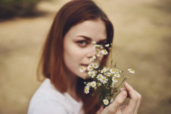 Romantische Frau mit einem Strauß Wildblumen in der Nähe von Bäumen im Feld — Stockfoto