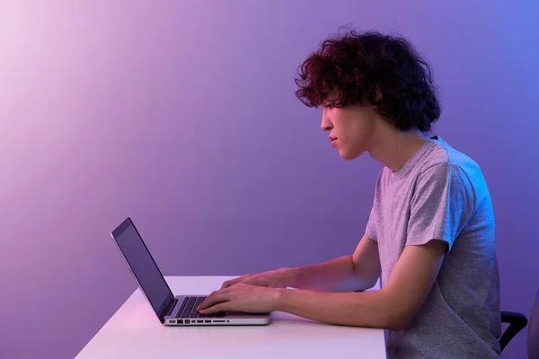 Cara ciberespaço brincando com na frente de um laptop violeta fundo — Fotografia de Stock