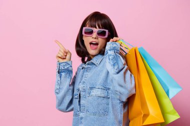 Mağazadan alışveriş yapan bir kadın eğlenceli pembe arka plan