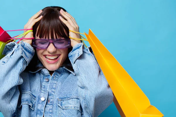선글라스를 끼고 쇼핑하면서 느끼는 즐거움을 표현 한 젊은 여자 — 스톡 사진
