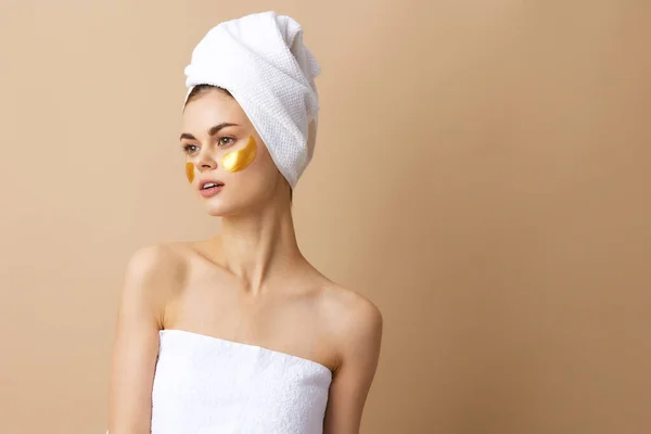 Wanita muda patch rejuvenation kulit peduli menyenangkan setelah mandi latar beige — Stok Foto