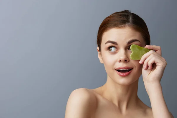 Pretty woman facial scraper skin care posing isolated background — Stock Photo, Image