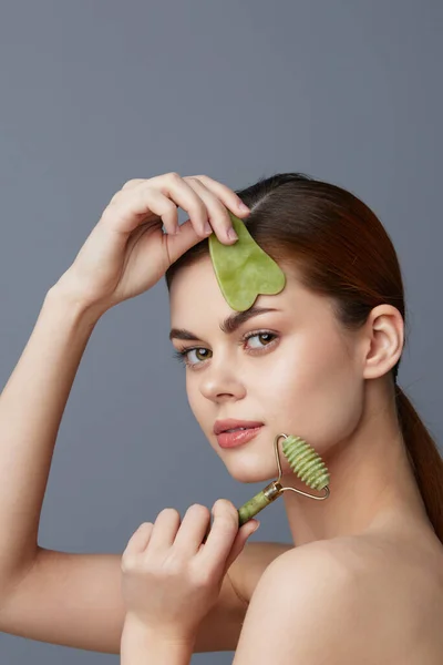 Beautiful woman scraper gua sha face care facial massage isolated background — Stock Photo, Image