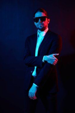 Ceketli yakışıklı adam kendine güvenen güneş gözlüğü takıyor.