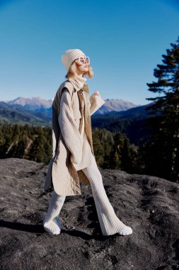 Sonbahar kıyafetleri içinde turist kaya mavisi gökyüzünde dinleniyor.