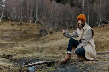 Turuncu şapkalı genç kadın. Sonbahar nehri rahatlaması.