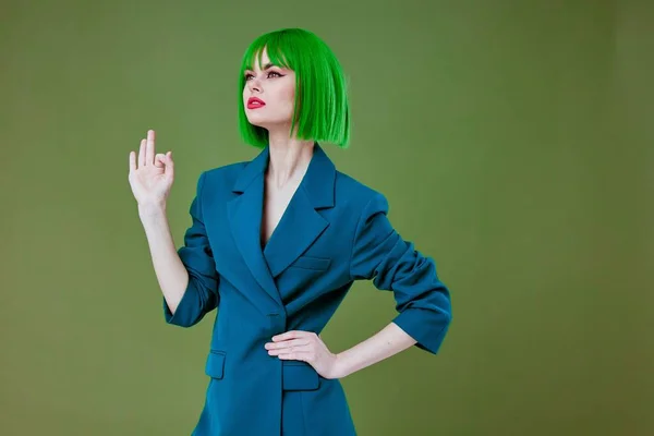 Θετική νεαρή γυναίκα φορώντας ένα πράσινο περούκα μπλε σακάκι με φόντο το χρώμα αμετάβλητη — Φωτογραφία Αρχείου