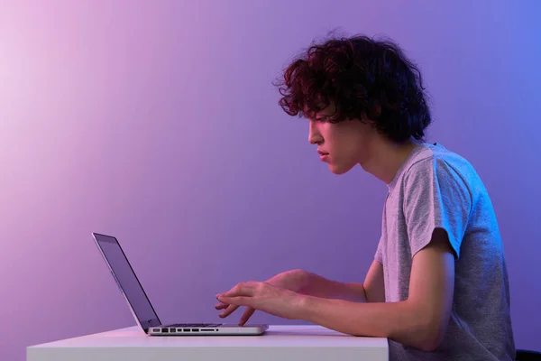 Homem ciberespaço brincando com na frente de um laptop violeta fundo — Fotografia de Stock