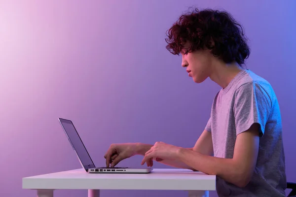 Homem ciberespaço brincando com na frente de um laptop violeta fundo — Fotografia de Stock