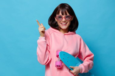 Genç kadın kaykay duyguları gençlik tarzı mavi arka plan