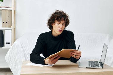 Beyaz koltukta oturan kıvırcık çocuk internetteki eğitim iletişimi.