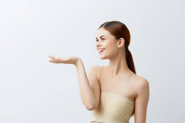 Genç bir kadın çıplak omuzlarıyla gülümsüyor. Temiz cilt cazibesi. Yakın plan yaşam tarzı.