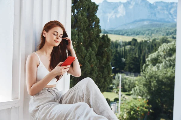 Mulher alegre sentado na varanda com telefone bela vista montanha verão Mountain View — Fotografia de Stock