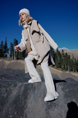 Uçurumun kenarında duran genç bir kadın doğa gezisi manzarası