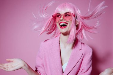 Genç bir kadının portresi, elleri ile pembe ceketli ve değiştirilmemiş bir stüdyo modeliyle jestler yapıyor.