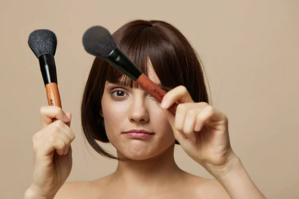 Belle femme pinceaux de maquillage près du visage épaules nues gros plan Lifestyle — Photo