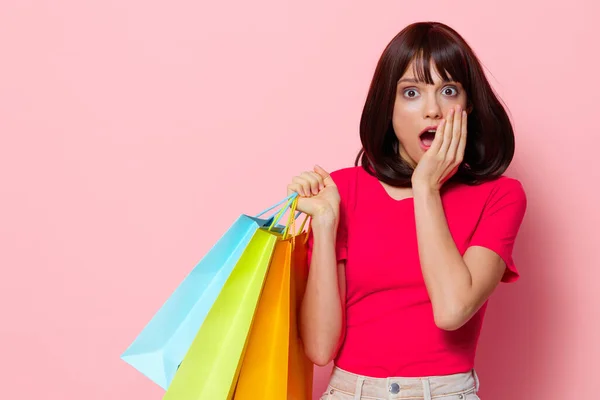 Joven mujer de compras en la tienda diversión entretenimiento rosa fondo —  Fotos de Stock