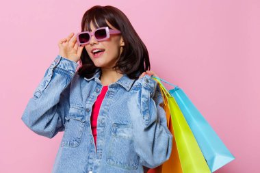 Renkli alışveriş çantalı kot ceketli kadın. Yaşam tarzı.