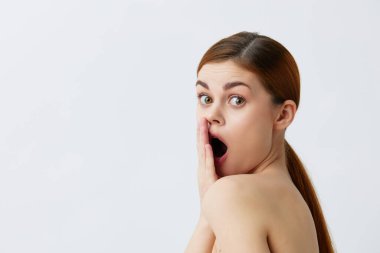 Kadın kızıl saçlı, çıplak omuzlu, kozmetik cilt bakımlı.