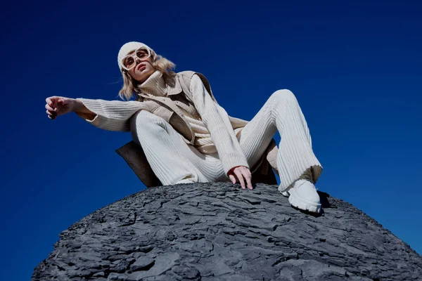 Mujer sentada en una piedra naturaleza cielo azul en un estilo de vida sombrero —  Fotos de Stock