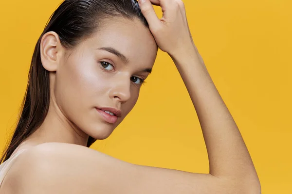Jonge vrouw schoon huid gezicht charme geel achtergrond — Stockfoto