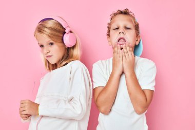 Oğlanın yanındaki kulaklıklı kız izole edilmiş arka planda birlikte oynuyorlar.