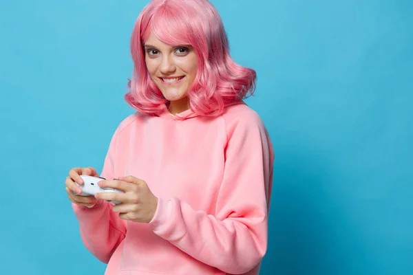 Hermosa mujer con gamepad rosa sudadera entretenimiento aislado fondo — Foto de Stock