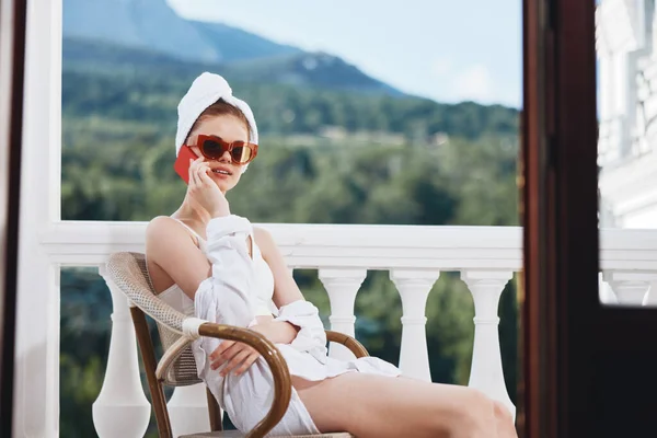 Donna alla moda seduta sul balcone a parlare al telefono Perfetta mattina di sole — Foto Stock