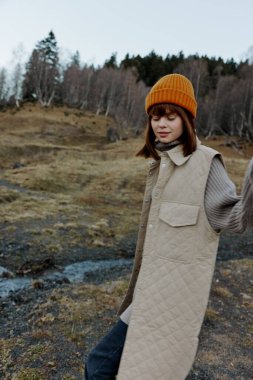 Sonbahar kıyafetleri içinde turist doğa ağaçları manzara gezer.