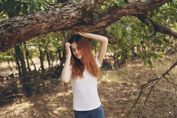 Kvinna vidröra träd gren med händerna på naturen i trädgården sommar livsstil och frisk luft — Stockfoto