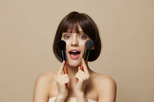 Junge Frau Make-up Pinsel in der Nähe des Gesichts nackten Schultern isoliert Hintergrund — Stockfoto