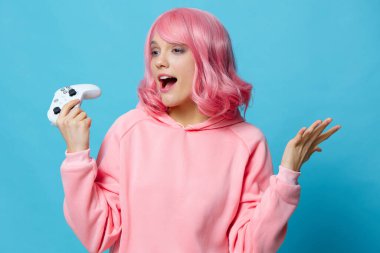 Pembe sweatshirt 'lü güzel bir kadın. Eğlence amaçlı mavi arka plan.