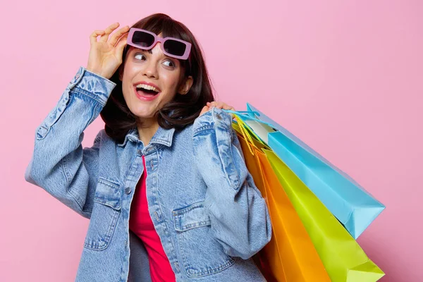 Mulher retrato em jaquetas de ganga com colorido sacos de compras isolado fundo — Fotografia de Stock