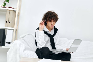 Masadaki koltukta oturan kıvırcık çocuk dizüstü bilgisayarın önünde yaşam tarzı teknolojisi.