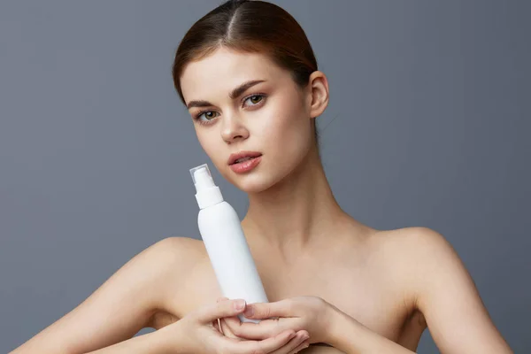 Hübsche Frau Hautpflege-Lotion mit nackten Schultern Grauer Hintergrund — Stockfoto