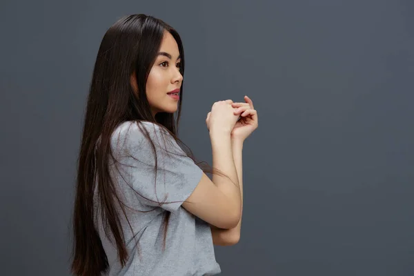 Portré nő hosszú haj egy szürke póló gesztikuláló kéz stúdió modell — Stock Fotó