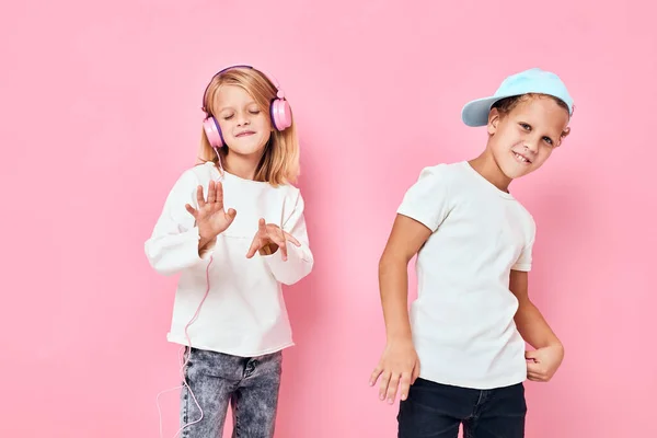 Chlapec v čepici a dívka hrají spolu růžové barvy pozadí — Stock fotografie