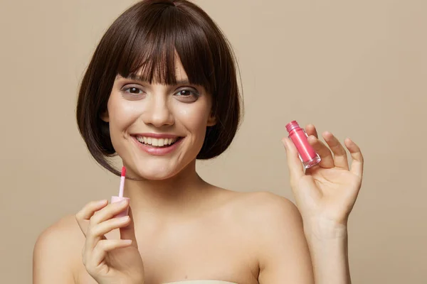 Brünette Lippenstift Kosmetik attraktiv aussehen posiert beige Hintergrund — Stockfoto