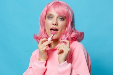 Güzel bir kadın dudak boyuyor Glamor Kozmetik mavi arka plan