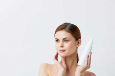 Genç kadın losyonu kavanozu. Temiz cilt bakımı.