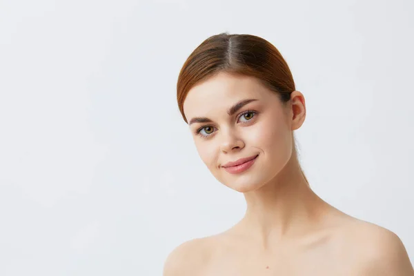 Jonge vrouw rood haar kale schouders cosmetica huidverzorging licht achtergrond — Stockfoto