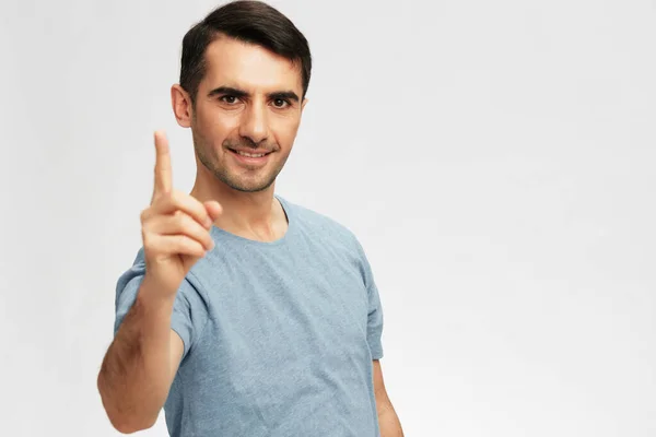 Uomo gesturing con le mani blu t-shirt posa sfondo chiaro — Foto Stock