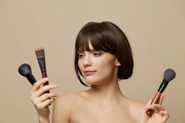 Frau brushe Kosmetik attraktiv aussehen posiert isoliert Hintergrund — Stockfoto