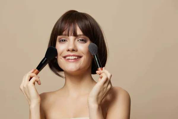 Frau Make-up Pinsel in der Nähe des Gesichts nackte Schultern abgeschnittene Ansicht — Stockfoto