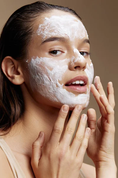 Kadın cilt bakımı için, yüzü izole edilmiş beyaz maske kullanın.